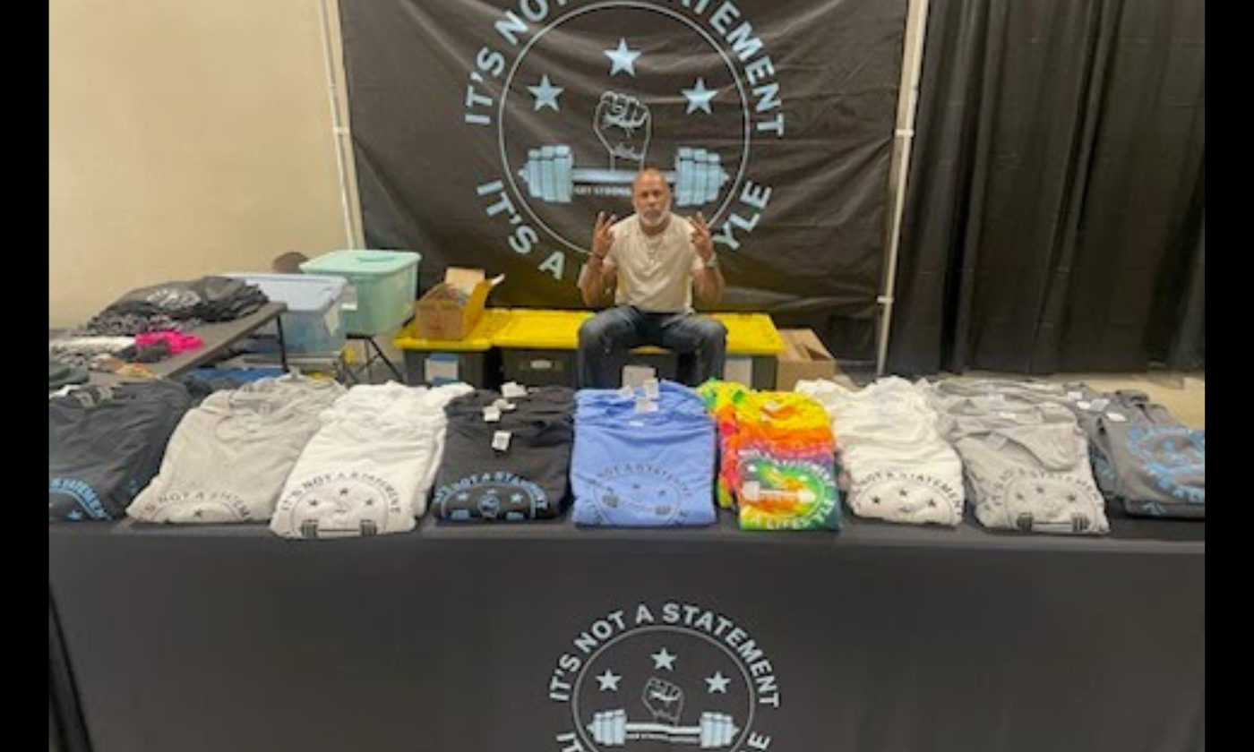 Huelett McGaugh with Get Strong Apparel Merchandise at a trade show.